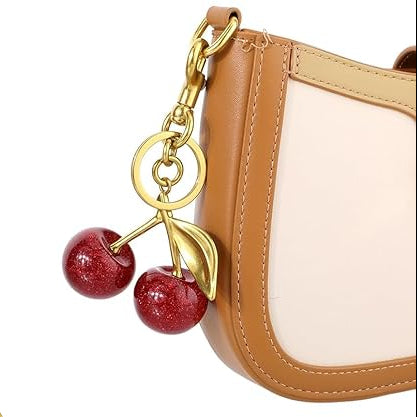 Cherry-themed keychain with gold accents on a white background