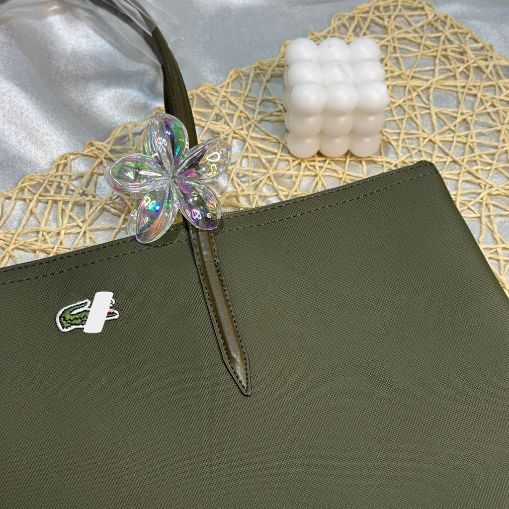 Green handbag with a brand logo on a textured surface