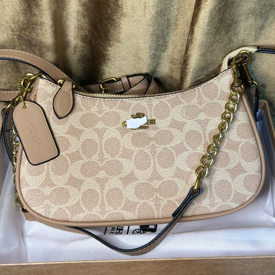 Beige handbag with gold chain strap on a beige background